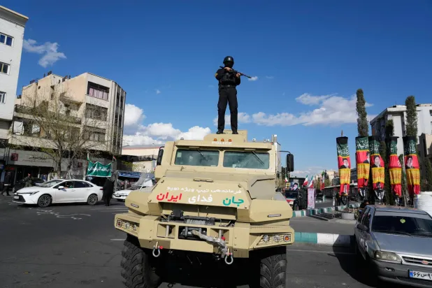 A member of police special forces stands guard on top their car at the Enqelab-e-Eslami square in downtown Tehran, Iran, Monday, March 30, 2026. (AP)