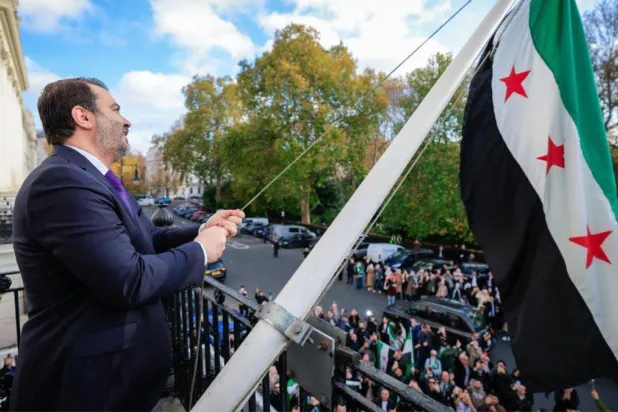 وزير الخارجية السوري أسعد الشيباني يرفع العلم السوري فوق مبنى السفارة في العاصمة البريطانية لندن أكتوبر 2025 (حساب الخارجية)