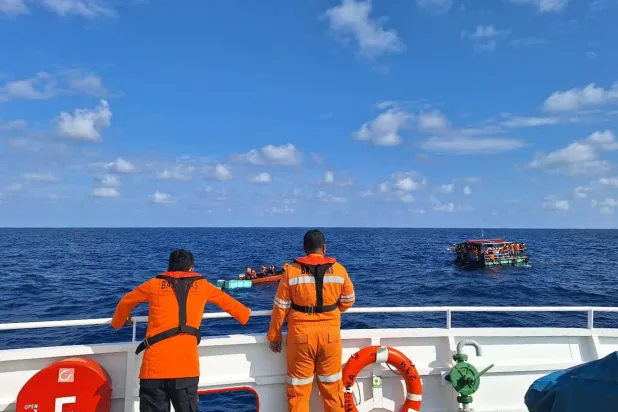  In this photo released by the Indonesian National Search and Rescue Agency (BASARNAS), crew look on as a rescue ship approaches a raft to evacuate the survivors boat that sank on Monday, in the waters off Taliabu Island, Indonesia, Tuesday, March 31, 2026. (BASARNAS via AP) 