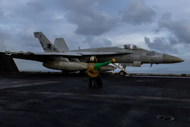 A US Navy sailor prepares to launch an F/A-18E Super Hornet from the flight deck of the Nimitz-class aircraft carrier USS Abraham Lincoln in support of the Operation Epic Fury attack on Iran at an undisclosed location, March 22, 2026. (US Navy/Handout via Reuters) 