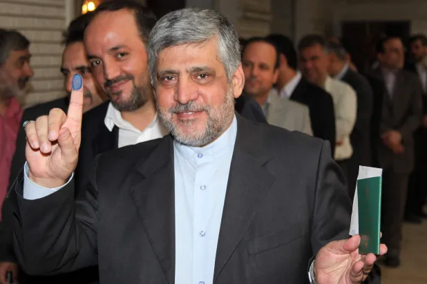 Iranian Ambassador to Syria Mohammad Reza Sheibani, shows his ink-stained finger as he votes in the first round of the Iranian presidential election on June 14, 2013 at the Iranian embassy in the Syrian capital, Damascus. (AFP)