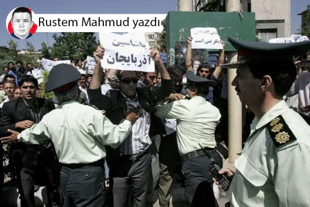 Tahran'daki İran Kültür Bakanlığı binası önünde, ‘Yaşasın Azerbaycan’ yazılı pankart taşıyan Azeri göstericileri dağıtmaya çalışan İran polisi, 28 Mayıs 2006 (AFP)