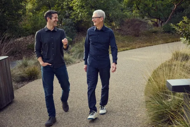 Apple'ın görevden ayrılan CEO'su Tim Cook (sağda) ve halefi John Ternus (solda), şirketin Silikon Vadisi'ndeki devasa genel merkezinin arazisinde yürüyor (Apple)