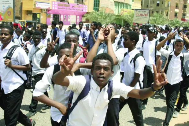 Hartum’da daha önce düzenlenen protestolar sırasında bir okulun öğrencileri (AFP)