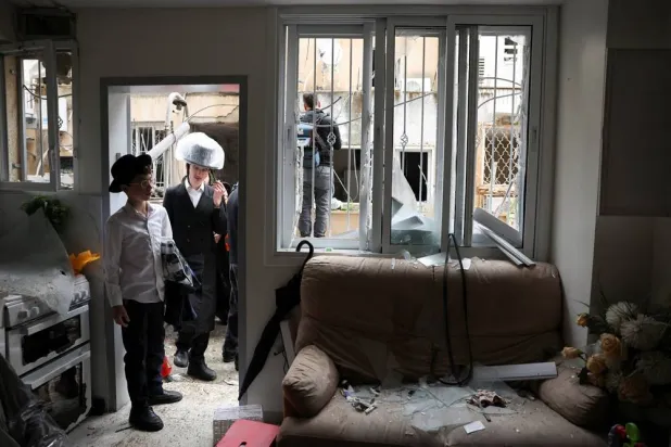 Ultra-Orthodox Jews look at the damage in a residential building, after Iran launched missiles towards Israel, amid the US-Israel conflict with Iran, in Bnei Brak, Israel April 1, 2026. (Reuters) 
