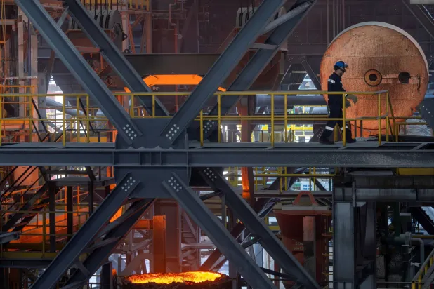 يمشي عامل فولاذ عبر فرن القوس الكهربائي في مصنع هاسليك ميلت قرب مدينة بيلجيك (رويترز)