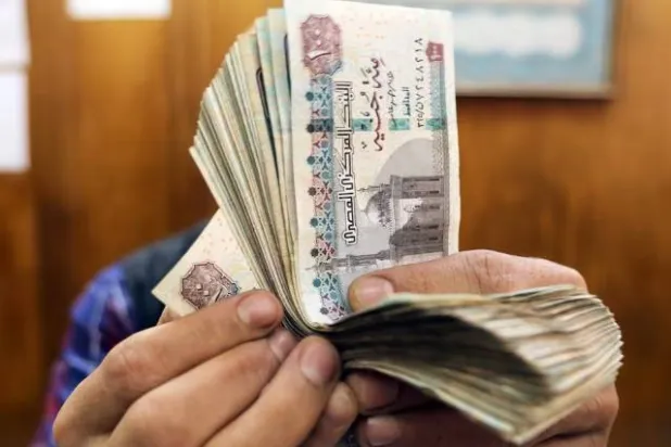 موظف يعد الجنيهات المصرية في مكتب صرافة وسط القاهرة (رويترز)