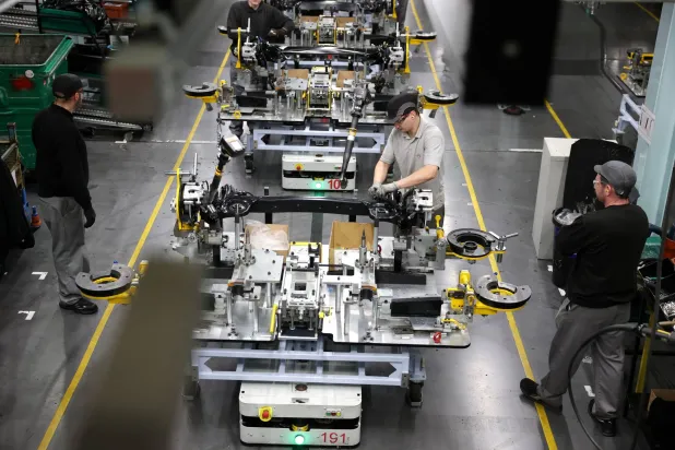 عمال يقومون بتجميع مكونات سيارة في مصنع نيسان بسندرلاند (رويترز)