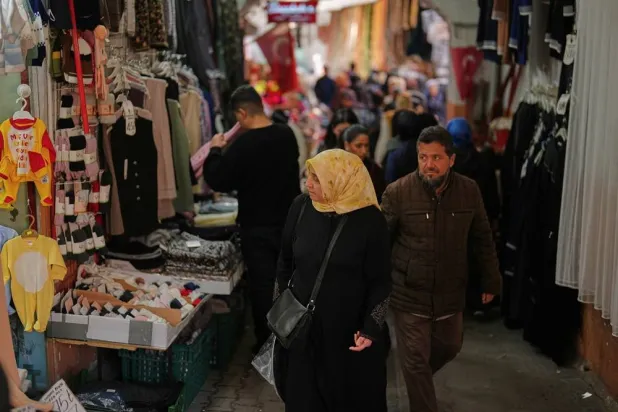  People walk past displayed items in a clothes shop at Eminonu commercial area, in Istanbul, Türkiye, Thursday, March 26, 2026. (AP)