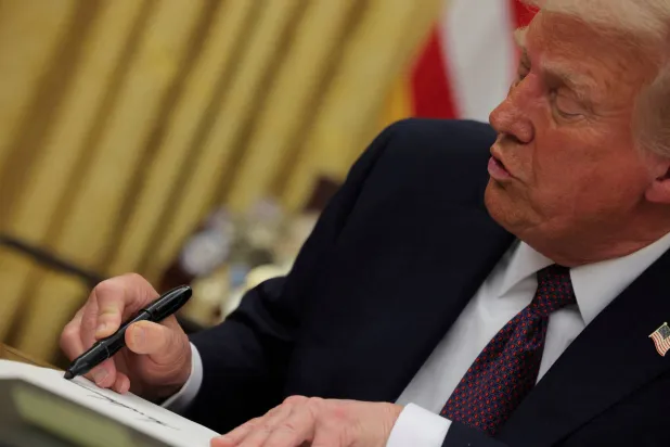 FILE PHOTO: US President Donald Trump signs documents at the White House in Washington, US, January 20, 2025.  REUTERS/Carlos Barria/File Photo