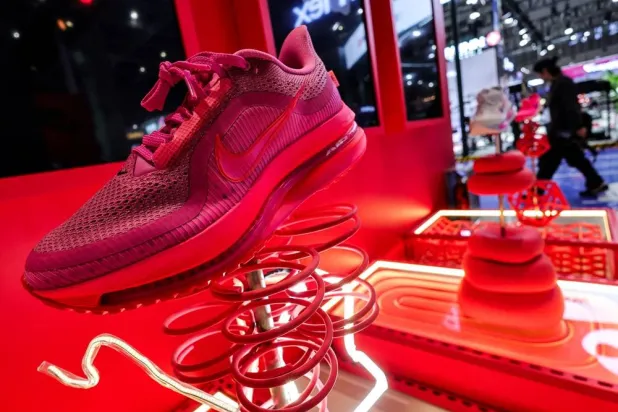 A man walks past Nike booth with installation of shoes at the 8th China International Import Expo (CIIE) venue in Shanghai, China, November 5, 2025. (Reuters) 