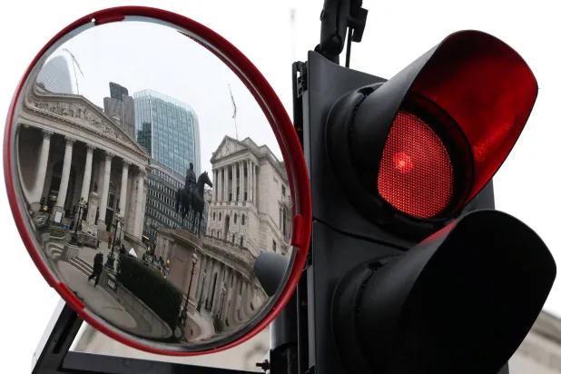 انعكاس مبنييْ بنك إنجلترا والبورصة الملكية في مرآة مرورية بلندن (رويترز)