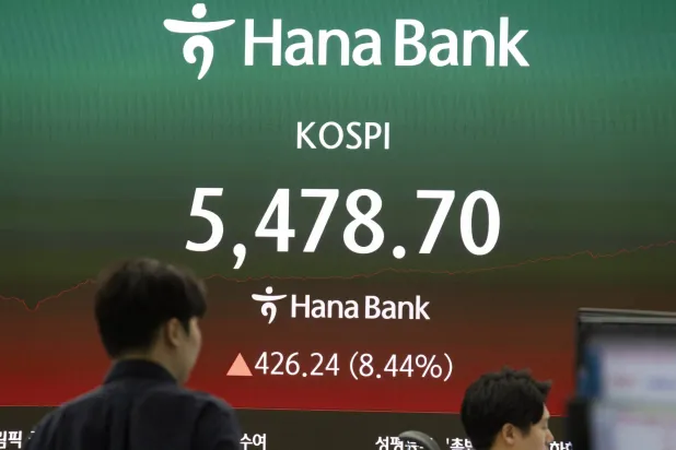 متداولون كوريون جنوبيون يعملون أمام شاشات في بنك هانا في سيول (إ.ب.أ)