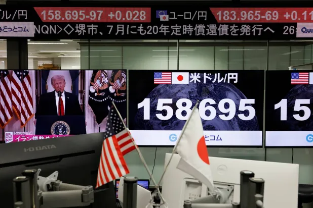شاشة تعرض خطاب ترمب بجوار شاشات تعرض سعر صرف الين مقابل الدولار في غرفة تداول بطوكيو (رويترز)