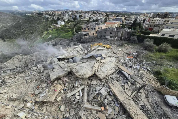 First responders clear the rubble from the site of an Israeli airstrike that targeted a building in the southern Lebanese village of Hanouiyeh, east of Tyre, on March 30, 2026. (AFP)