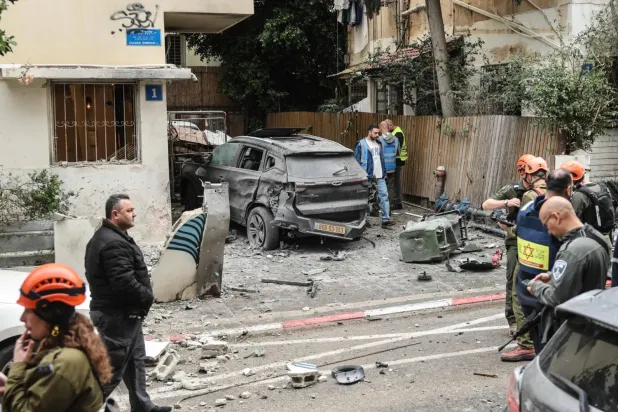İsrail güvenlik güçleri, 1 Nisan’da Tel Aviv’deki bir yerleşim bölgesine düşen İran menşeli roketin verdiği hasarı inceliyor. (AFP)
