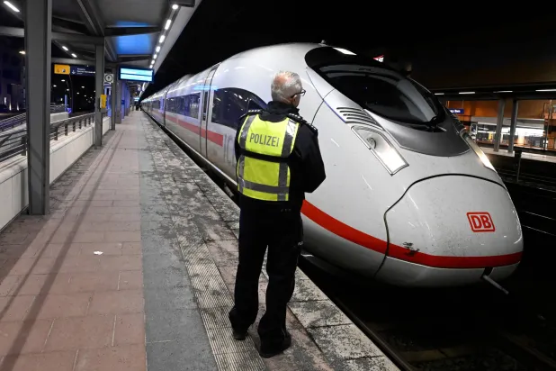 A police officer stands on a platform at Siegburg station where a Deutsche Bahn ICE train is parked, in Siegburg, Germany, early Friday, April 3, 2026, after a man was arrested on Thursday after threatening an attack on a high-speed train. (Roberto Pfeil/dpa via AP)