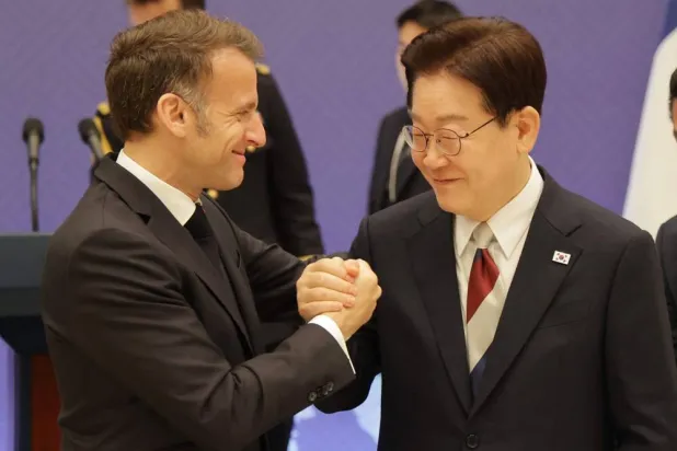  French President Emmanuel Macron (L) shakes hands with South Korean President Lee Jae-myung (R) prior to a toast during a state lunch in Seoul on April 3, 2026. (AFP) 