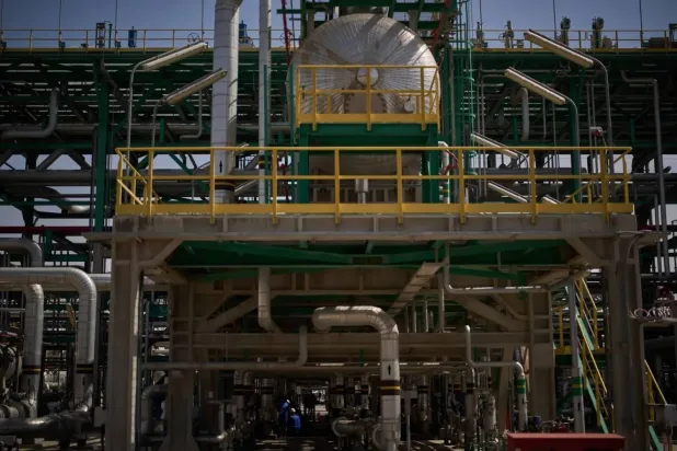 Workers carry out maintenance on a pipeline at a gas separation station in the Zubair oil field near Basra (AP). 