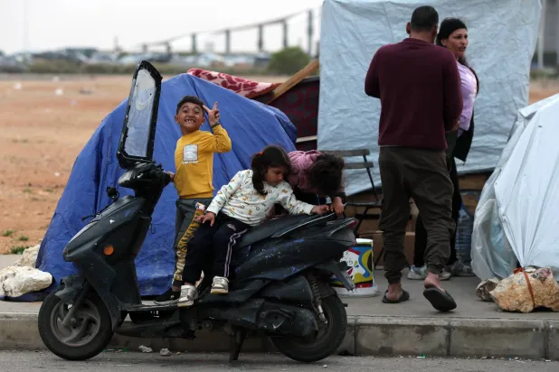 أطفال نازحون مع عائلاتهم عند الواجهة البحرية في وسط بيروت (إ.ب.أ)