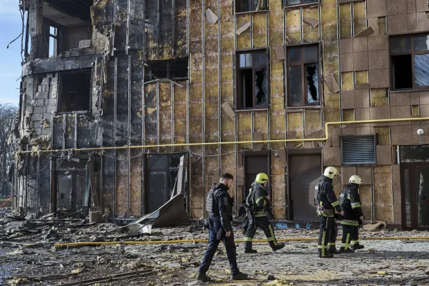 رجال إنقاذ أوكرانيون بموقع غارة روسية استهدفت مبنى سكنياً في خاركيف (إ.ب.أ)