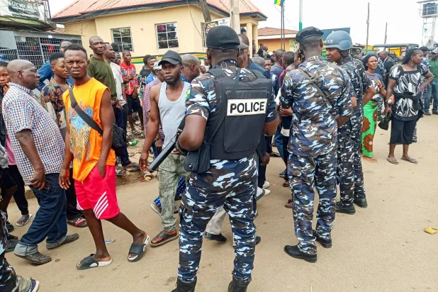 رجال شرطة ومواطنون في مكان الهجوم المسلح بجوس عاصمة ولاية بلاتو النيجيرية الاثنين (رويترز)