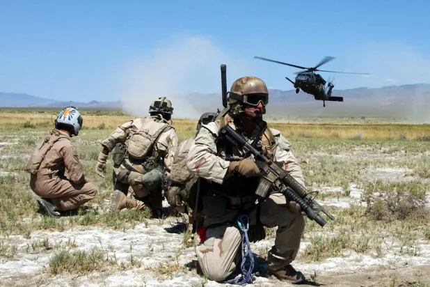  ABD Hava Kuvvetleri’ne bağlı paraşütlü kurtarma ekipleri ile ‘hayatta kalma’ tatbikatını canlandıran bir kişi, ordunun eğitim tatbikatının bir parçası olarak helikopterin inişini izliyor. (Arşiv – ABD Hava Kuvvetleri)