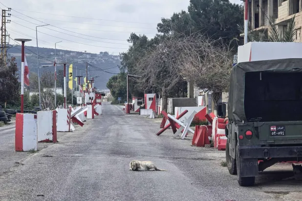 A dog lies an empty road outside a Lebanese army outpost in the area of Naqoura in southern Lebanon on March 27, 2026. (AFP)