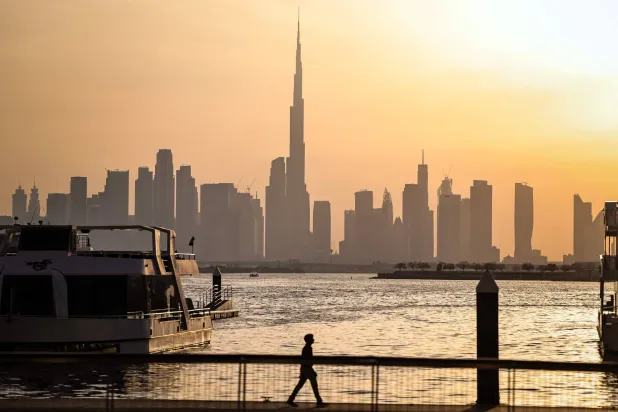  A man walks along Dubai's Creek Harbor, with the Burj Khalifa visible in the background, on April 3, 2026. (AFP) 