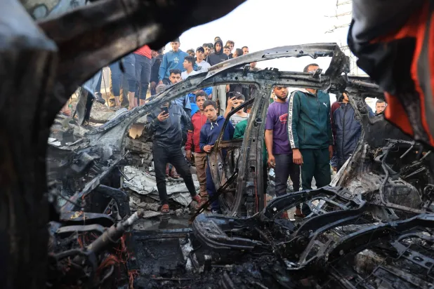 Palestinians inspect a vehicle targeted by an Israeli strike in Maghazi camp for Palestinian refugees in the central Gaza Strip on April 4, 2026. (AFP)