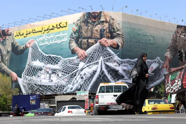 Traffic passing a huge political billboard reading in Persian "The Strait of Hormuz will remain closed", in Enghelb square in Tehran, Iran, 05 April 2026. (EPA)