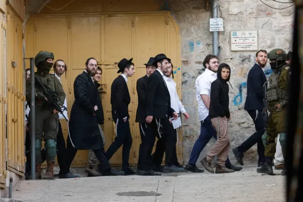 جنديان إسرائيليان يشاركان في حراسة جولة أسبوعية للمستوطنين الإسرائيليين في الخليل بالضفة الغربية المحتلة 14 فبراير 2026 (رويترز)