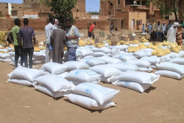 سودانيون يتلقون مساعدات من برنامج الأغذية العالمي في أم درمان يوم 11 مارس الماضي (أ.ف.ب)