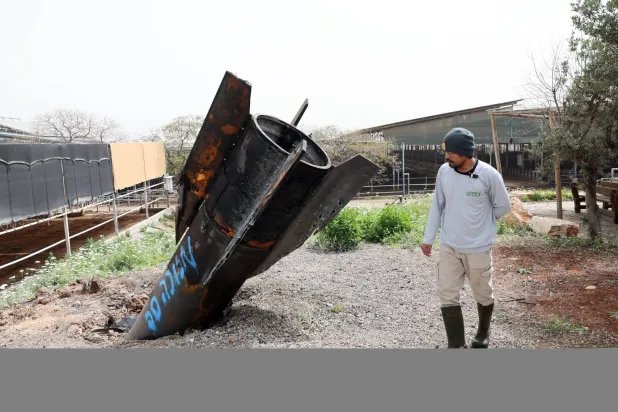بقايا صاروخ إيراني سقط على مزرعة أبقار في مستوطنة إسرائيلية بالضفة الغربية (إ.ب.أ)