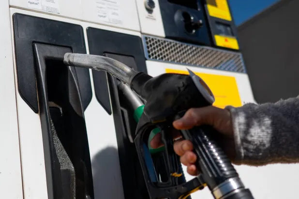 امرأة تستخدم مضخة لتعبئة خزان وقود سيارتها في محطة وقود بمدينة روندا، قرب مالقة (أ.ف.ب)