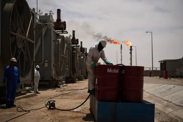 A worker collects engine oil as he works at a degassing station in Zubair oil field, near Basra, Iraq, Saturday, March 28, 2026. (AP Photo/Leo Correa)