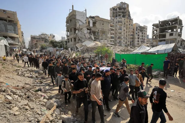 مشيعون يحملون يوم الاثنين جثمان الفلسطيني عبد الرحمن الخضري الذي قُتل في غارة إسرائيلية في مدينة غزة يوم الأحد (رويترز)