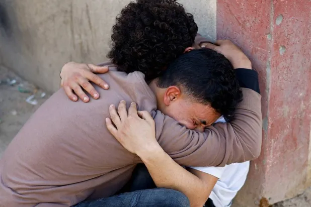  Palestinians react following an Israeli strike outside a school sheltering displaced people, according to medics, at Al-Aqsa Martyrs Hospital in Deir al-Balah in the central Gaza Strip, April 6, 2026. (Reuters)