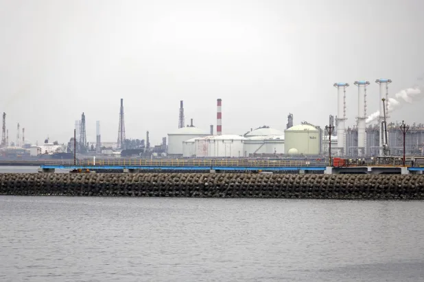 خزانات تخزين النفط الخام الضخمة تظهر في خلفية الصورة في مصفاة سوديغاورا بمدينة سوديغاورا - محافظة تشيبا - خليج طوكيو (إ.ب.أ)