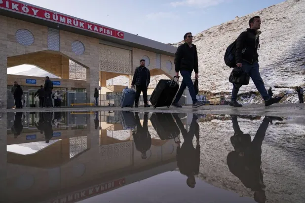 Travelers cross from Iran into Türkiye at the Kapikoy border crossing in eastern Van province, Türkiye, Saturday, April 4, 2026. (AP) 