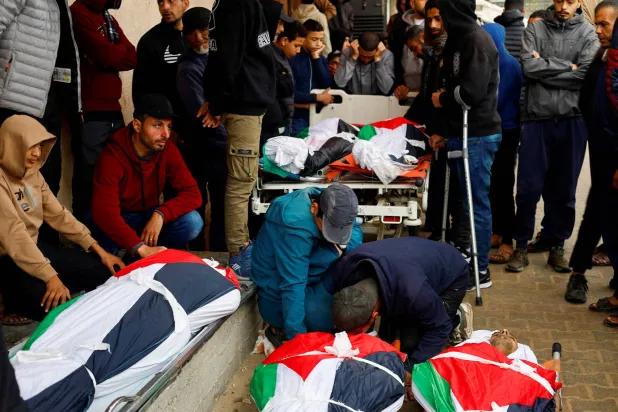 جنازة فلسطينيين قُتلوا بغارة إسرائيلية في مستشفى شهداء الأقصى بدير البلح وسط قطاع غزة (رويترز)