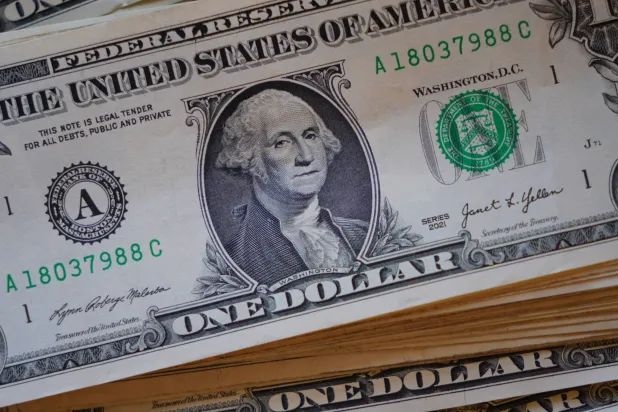 A portrait of George Washington is displayed on a stack of US one-dollar bills in Dallas, Tuesday, April 7, 2026. (AP Photo/LM Otero)
