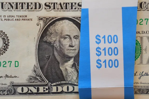 صورة لجورج واشنطن معروضة على كومة من الأوراق النقدية الأميركية من فئة الدولار الواحد في دالاس (أ.ب)