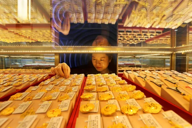 A saleswoman adjusts gold jewelry on display for sale in a store in Jiangsu Province, eastern China (AFP)