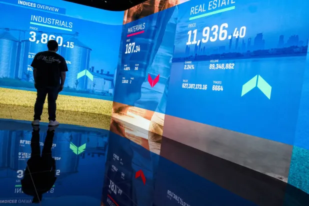 A man follows the stock market at the Dubai Financial Market in Dubai (EPA)