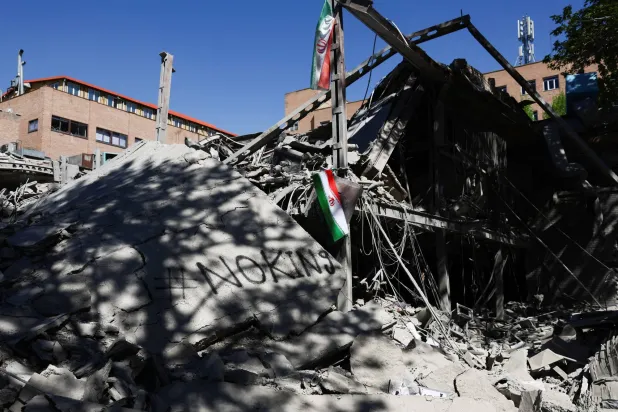  علم إيراني يظهر وسط أنقاض مبنى تابع لاحد الجامعات في طهران (رويترز)