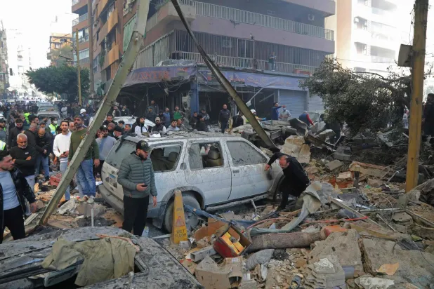 عناصر الدفاع المدني ومواطنون في موقع استُهدف بقصف إسرائيلي في منطقة كورنيش المزرعة في بيروت (أ.ف.ب)