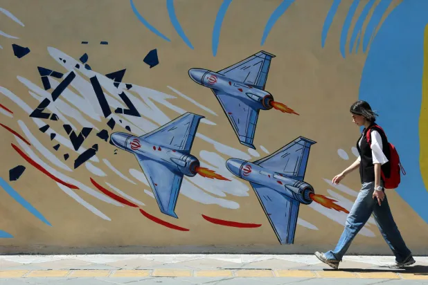 إيرانية تمر أمام لوحة جدارية مناهضة للولايات المتحدة وإسرائيل في طهران الأربعاء (إ.ب.أ)