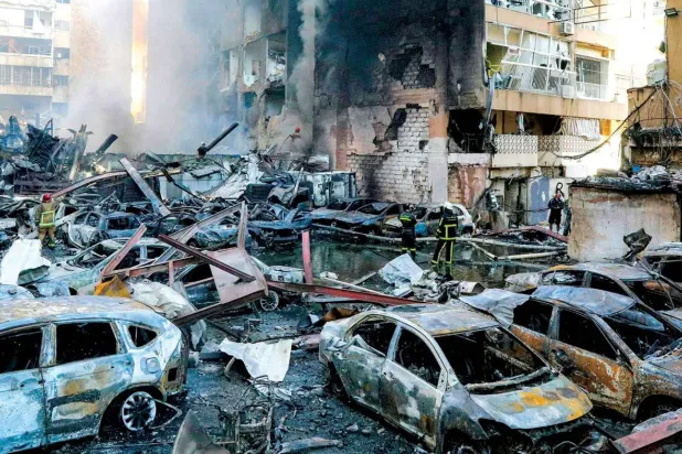 Dün Beyrut'un Korniş Mezraa Mahallesi’nde İsrail'in düzenlediği hava saldırısı sonucu çıkan yangını söndürmeye çalışan itfaiye ekipleri (AFP)