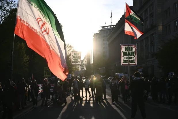 Demonstrators flags of Iran and Lebanon during a protest against US military action in Iran near the White House in Washington, DC, on April 8, 2026. (Photo by Brendan SMIALOWSKI / AFP)